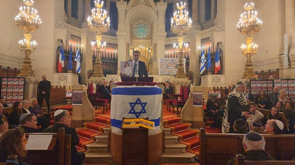 נאומו של אלעד דנוך עם תמונתה של עמית סוסנה, צילום: אליין עזריה